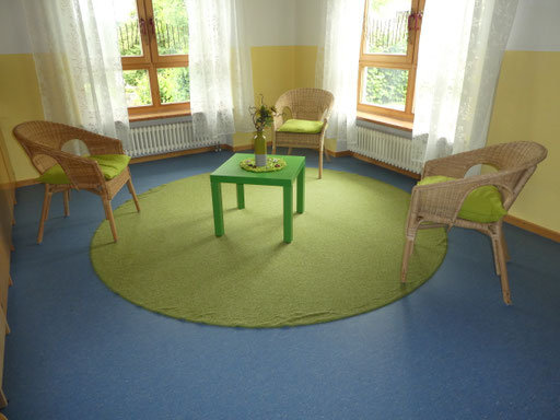 Gesprächsraum mit Tisch, Stühlen und Sitzgelegenheiten.