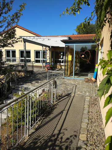Außenansicht des Kinderhauses Santa Maria mit Eingangsbereich und barrierefreiem Zugang.